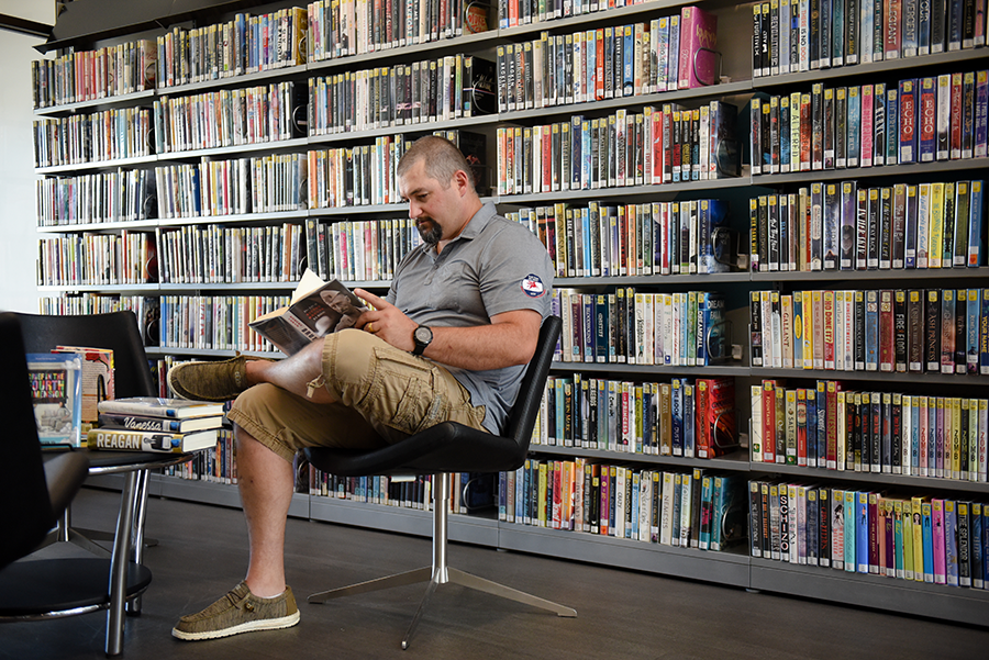 Man sitting in the adult section reading a book