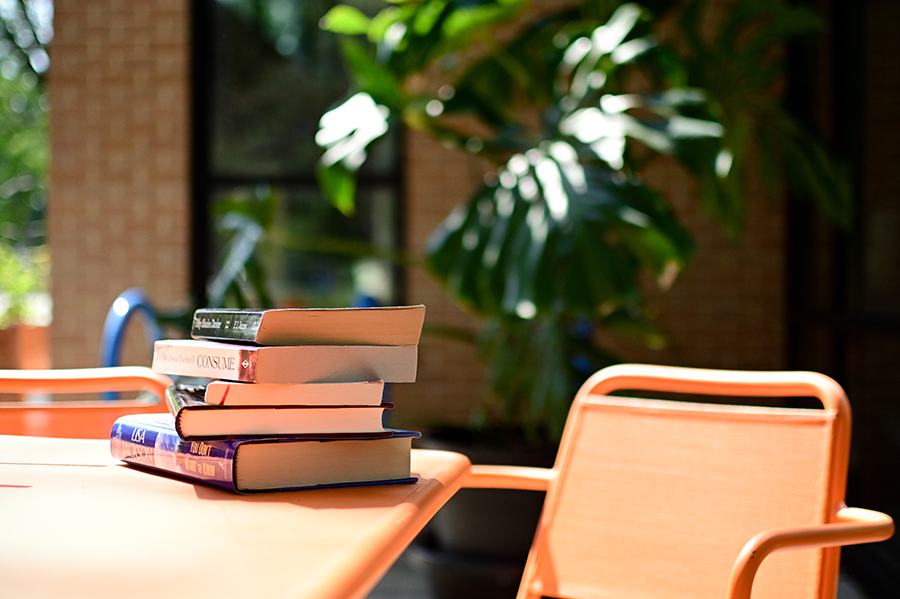 Stack of books on an orange outdoor table