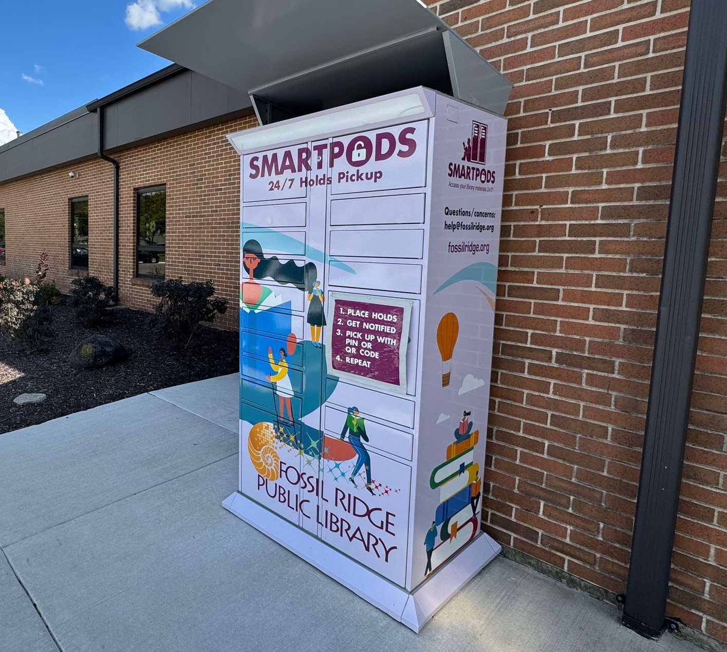 Smartpods locker with colorful wrap outside Fossil Ridge Library entrance