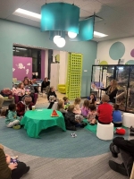 Children and adults gathered in the library for storytime with their stuffed animals